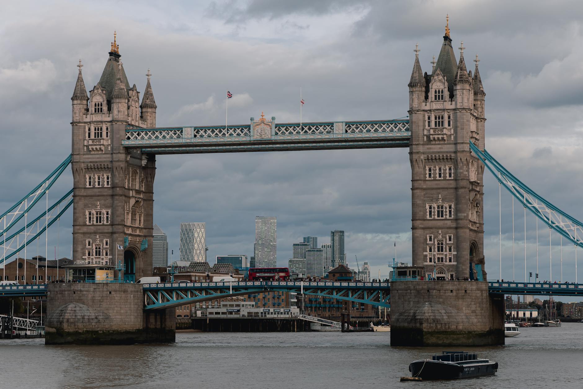 Iconic Tower Bridge view with Thames River in London, capturing classic architecture against a moody skyline.