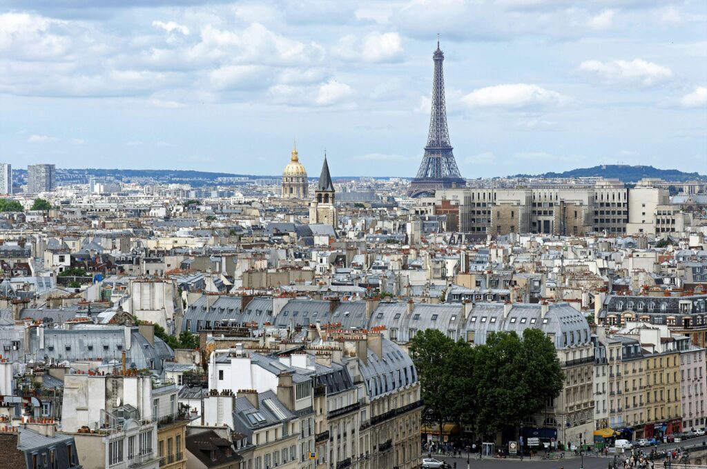 Stunning aerial shot of Paris cityscape featuring the iconic Eiffel Tower and historic architecture.